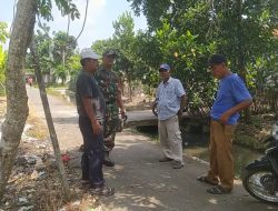 Pastikan Aliran Lancar, Babinsa dan Perangkat Desa Sisir Saluran Air di Telukhaur
